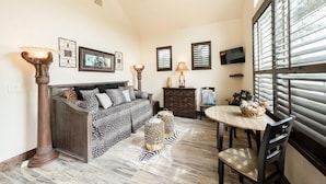 A living room with a sofa, a coffee table, and a zebra-patterned rug.