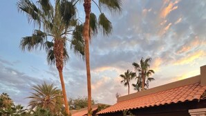 Un resort con piscina, sillas de descanso y una estructura de techo de paja.