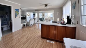 Una cocina amplia con armarios de madera, una isla central y un ventilador de techo.