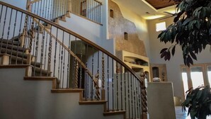 Un intérieur moderne agrémenté d’un escalier en colimaçon, d’une grande plante et d’un design de plafond original.
