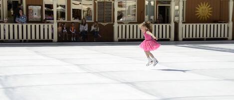 Una patinadora artística amb un vestit rosa actua sobre una pista de gel.