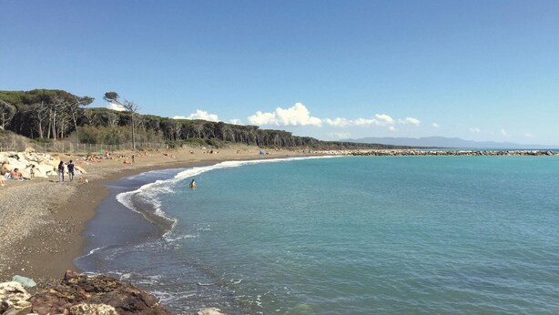 A beach with clear blue water, rocky shoreline, and people sunbathing. - 3 bedroom awesome home in Sassetta (Sassetta)