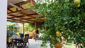 An outdoor patio with a wooden pergola, a table with chairs, and potted plants. - Villa Carpe Diem -Luxury Villa with private pool     2 km from the beach! (Adele)