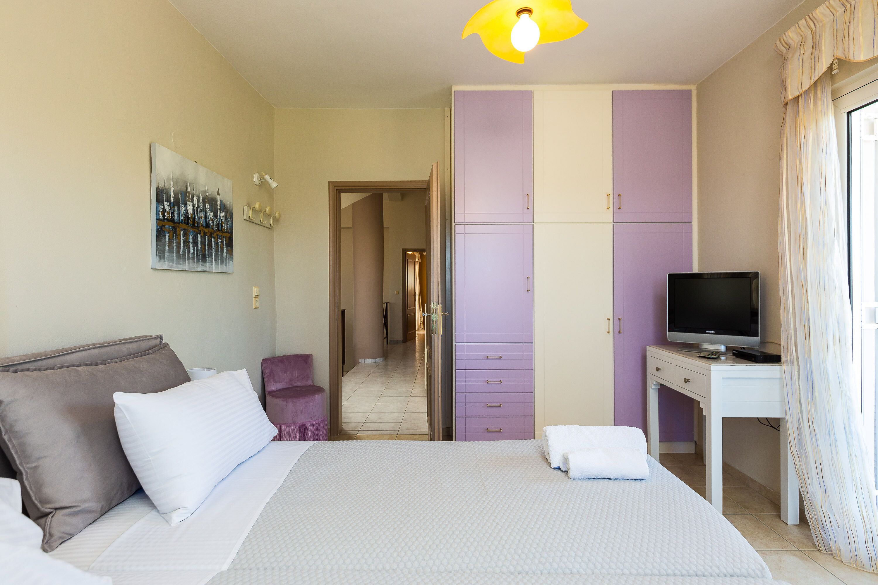 Ein Schlafzimmer mit einem Bett, einem Fernseher auf einem Schreibtisch und einem Kleiderschrank.