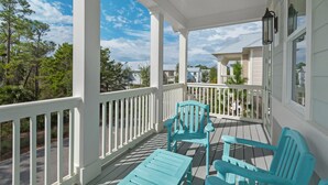 A covered porch with white railings and turquoise furniture. - Grayton Beach Vacation House- park your car, hop on a bike, explore! (Santa Rosa Beach)