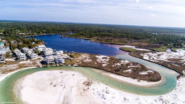An aerial view of a coastal area with a large body of water, a sandy beach, and residential buildings. - Grayton Beach Vacation House- park your car, hop on a bike, explore! (Santa Rosa Beach)