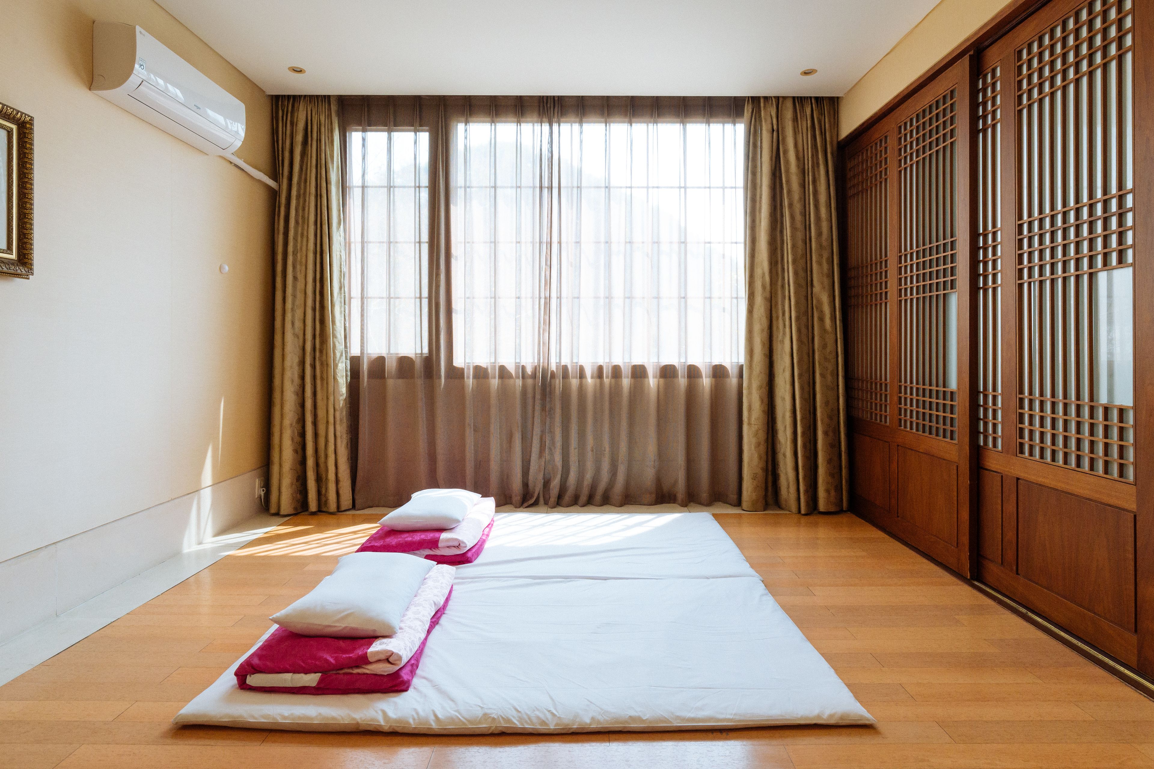 Une chambre d’hôtel avec un grand lit, une porte coulissante en bois et une fenêtre avec des rideaux.