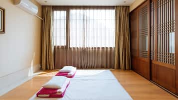 Une chambre d’hôtel avec un grand lit, une porte coulissante en bois et une fenêtre avec des rideaux.