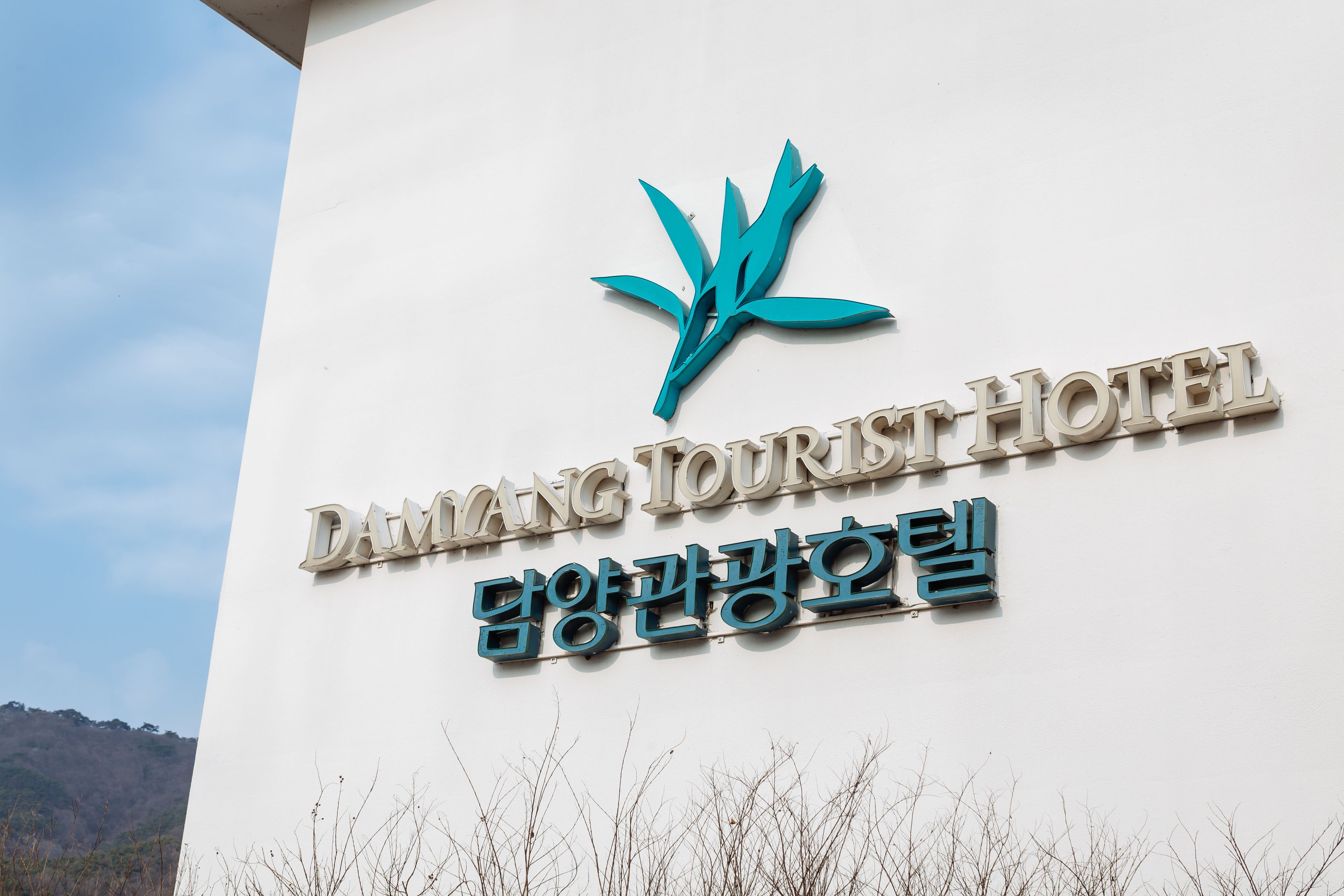 Un cartel del Hotel Damang Tourist con un logotipo y texto en inglés y coreano.