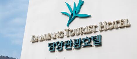 Un cartel del Hotel Damang Tourist con un logotipo y texto en inglés y coreano.