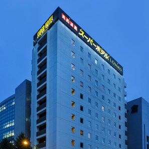 Een hoog hotelgebouw met meerdere verdiepingen en balkons.