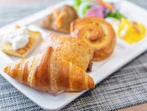 Een bord met croissants en een salade.