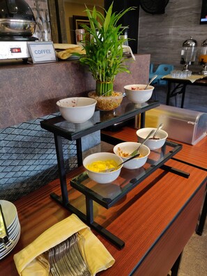 Una barra de buffet con diferentes opciones de comida y una estación de café.