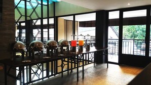 A bar area with a long counter, multiple bar stools, and a view of the outdoors through large windows. - Havana Mutiara Belitung Hotel (Tanjung Pandan)