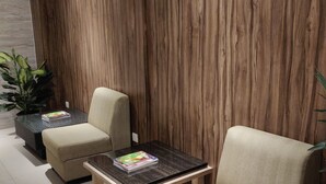 A modern living room with two beige armchairs, a small coffee table, and a potted plant. - Havana Mutiara Belitung Hotel (Tanjung Pandan)