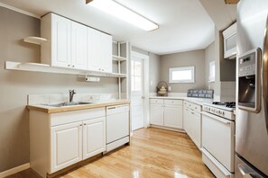Enjoy cooking in this well-equipped kitchen with a sink, stove, and refrigerator.