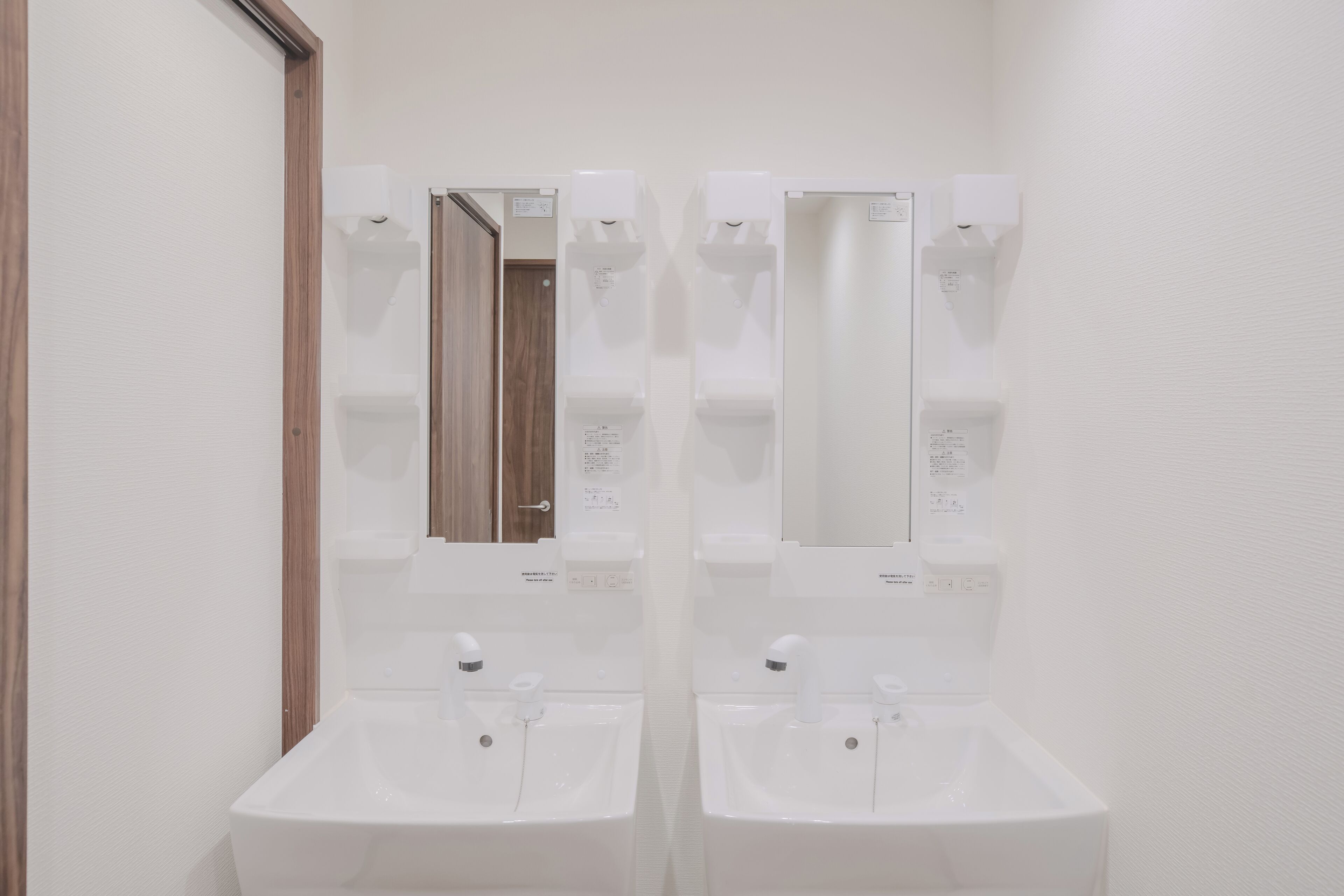 A bathroom with two sinks, a mirror, and a wooden door.