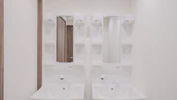 A bathroom with two sinks, a mirror, and a wooden door.