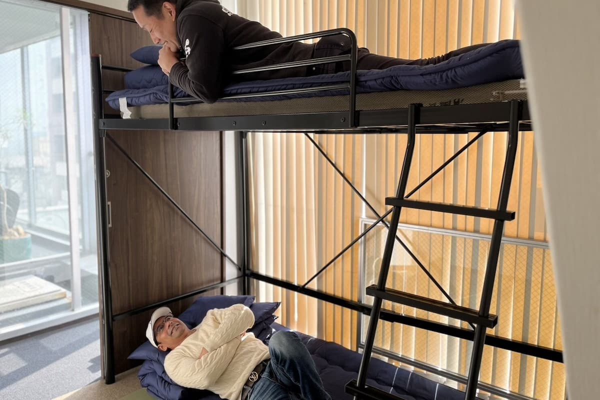 A bunk bed with two levels, each with a mattress and pillows.