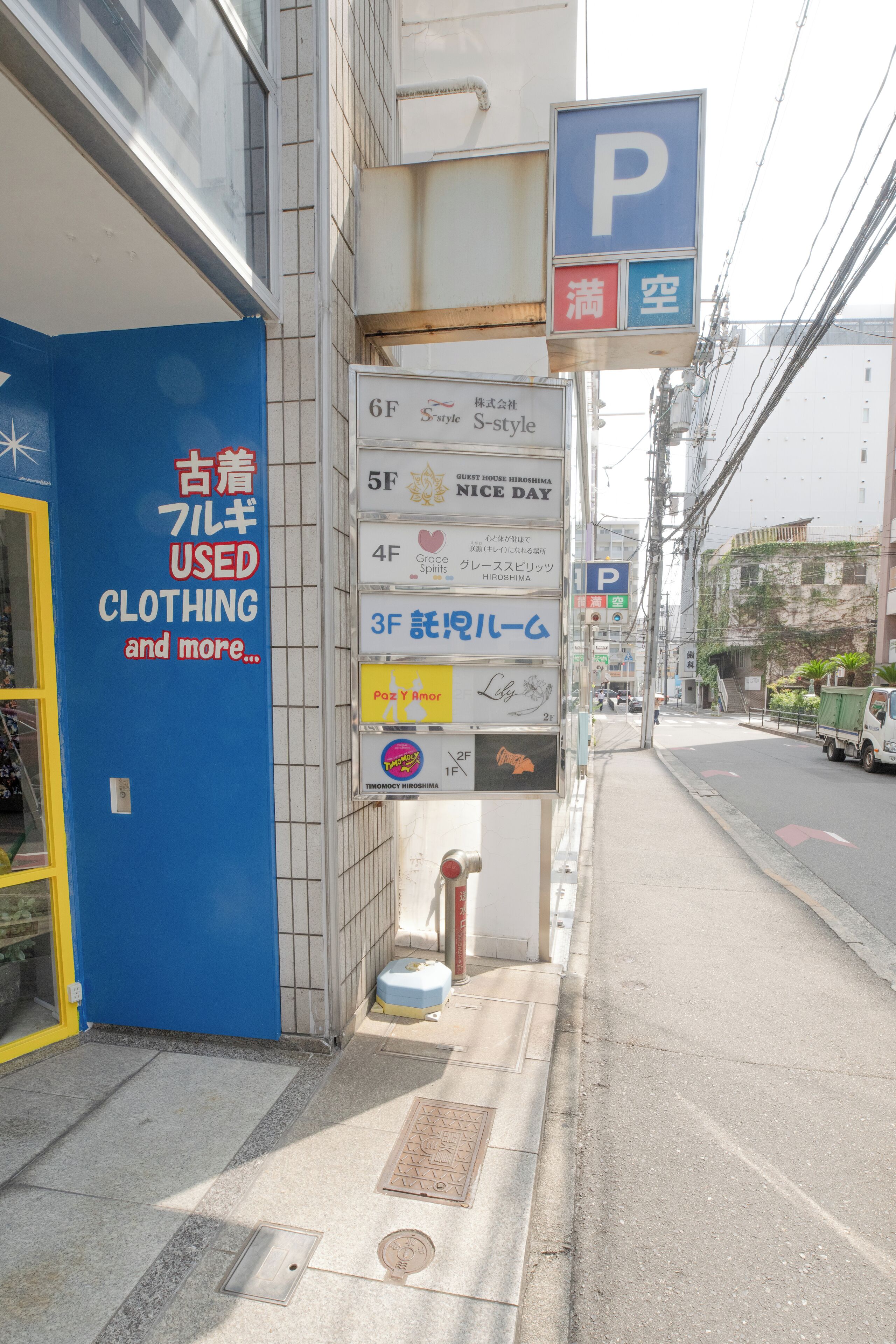 A building with a blue sign advertising used clothing and more.