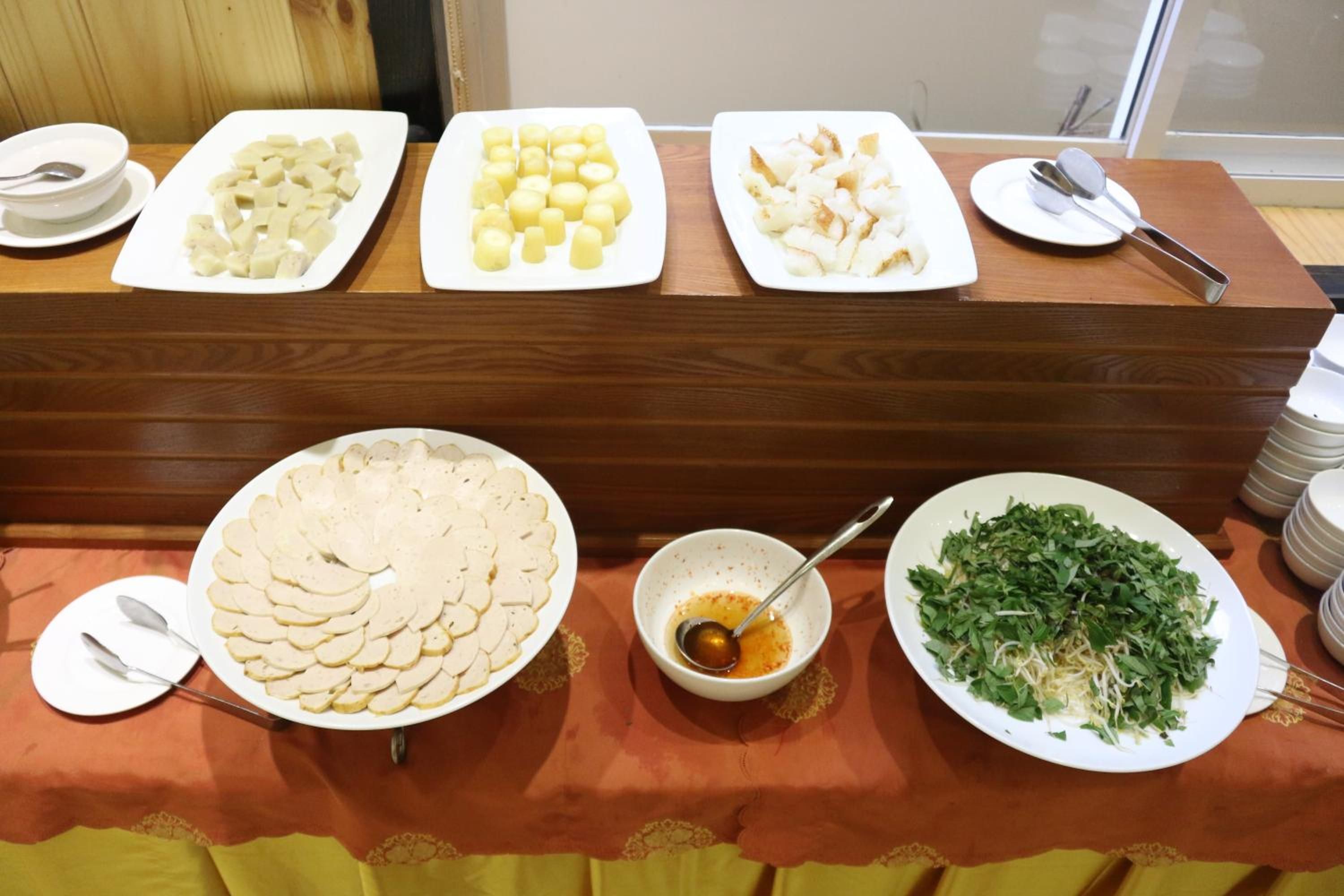 Una mesa de buffet con diversos alimentos y utensilios.