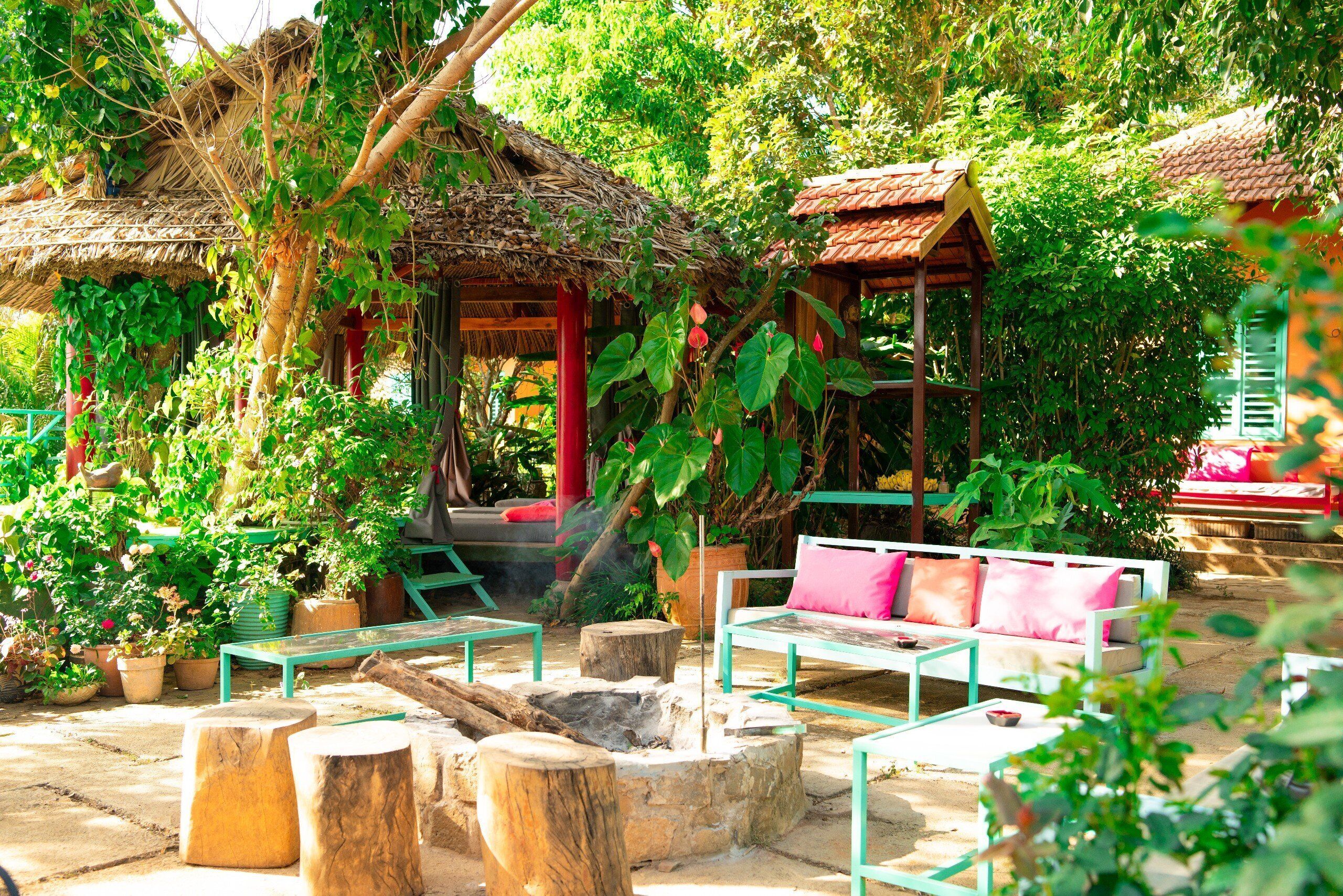 A rustic outdoor seating area with wooden benches and a thatched-roof structure.