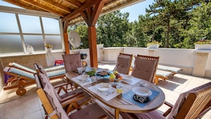 A wooden dining table with chairs, a satellite dish, and a view of trees. - Nice apartment in Rijeka (Rijeka)