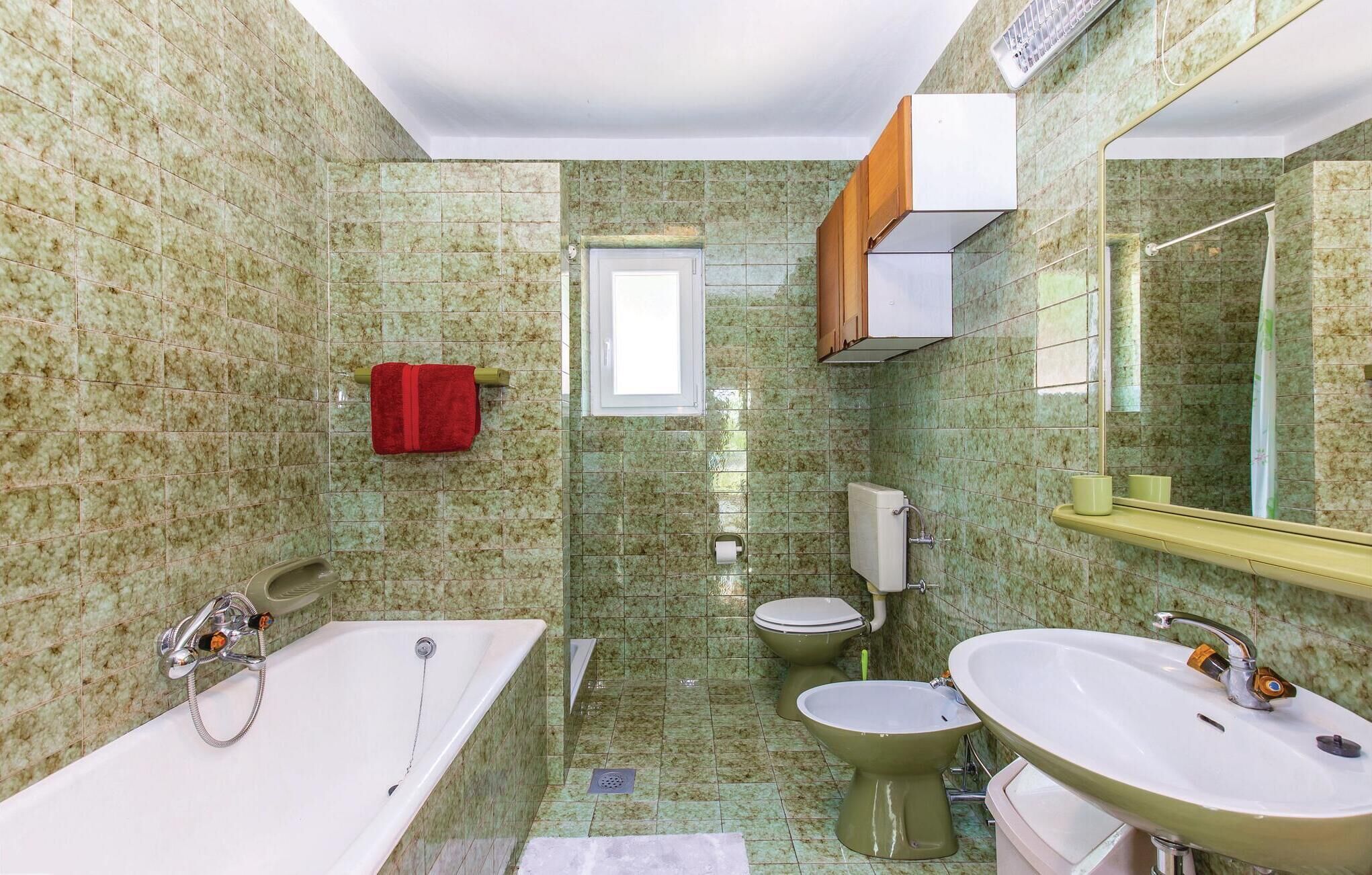 Une salle de bain équipée d’une baignoire, de toilettes, d’un bidet et d’un lavabo.