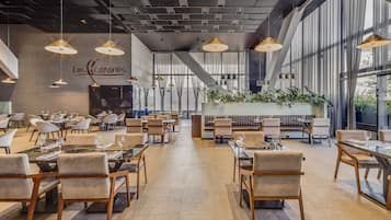 Enjoy dining at Los Canarios, where guests can sit at one of the many tables and chairs, surrounded by pendant lighting and large windows.