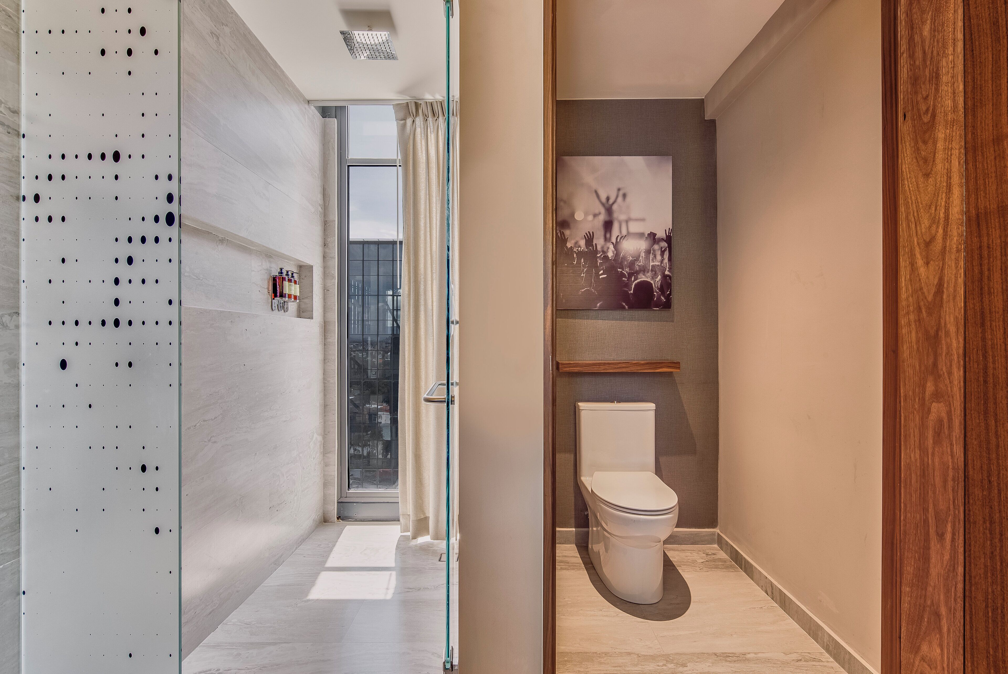 Casa de banho moderna com sanita, área de duche e porta de vidro para varanda.