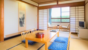 A traditional Japanese room with tatami flooring, a low wooden table, and a tatami mat couch. - Chikugofunagoya Kouennoyado (Chikugo)