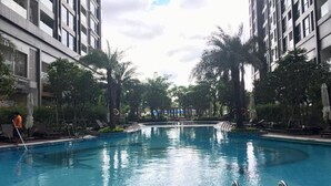 Una piscina al aire libre, sombrillas, sillones reclinables de piscina