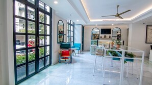 A spacious kitchen with a large window, a ceiling fan, and a bar area. - Jambuluwuk Thamrin Hotel (Jakarta)