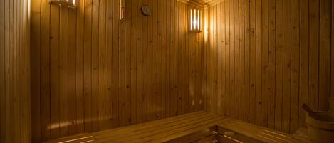 A wooden sauna with benches and a small window.