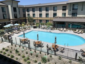 A modern hotel with a large pool area, sun loungers, and outdoor seating. - Courtyard by Marriott Thousand Oaks Agoura Hills (Agoura Hills)
