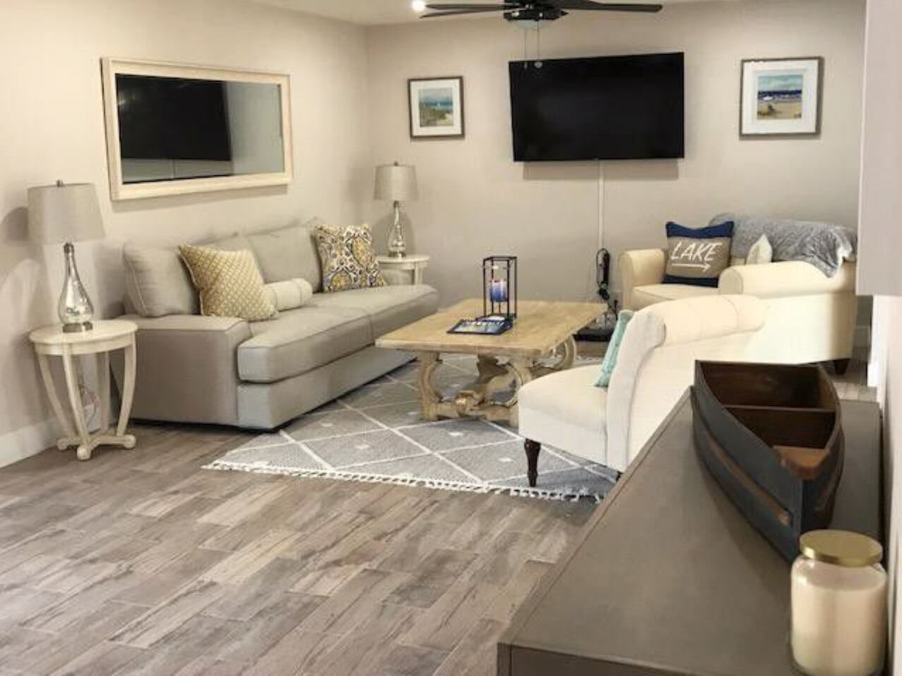 A living room with a sofa, coffee table, and a TV mounted on the wall.