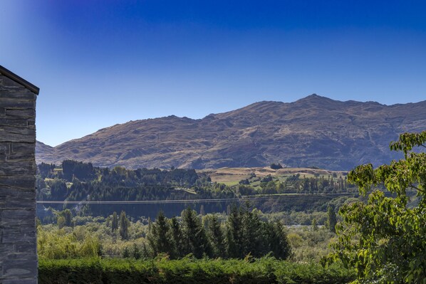 A mountainous landscape with a stone building in the foreground. - Amazing Winter Escape with Spectacular Views (Queenstown)