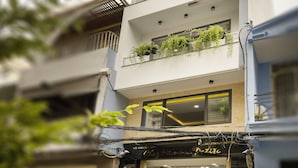 A modern hotel with multiple floors, large windows, and outdoor plants on balconies. - Chez Mimosa Petite (Ho Chi Minh City)