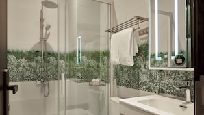 A modern bathroom with a glass-enclosed shower, a white toilet, and a vanity with a mirror. - Chez Mimosa Petite (Ho Chi Minh City)