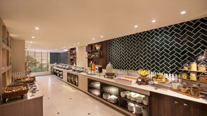 Zona de bufé con diversos alimentos y utensilios.