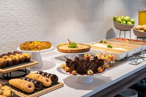 A buffet with various desserts and fruits.