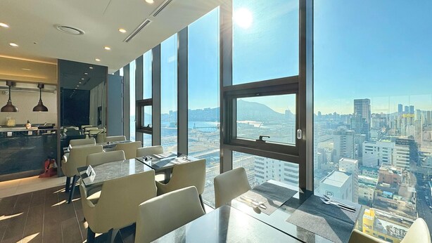 A modern dining area with large windows offering a city view. - Ramada Encore by Wyndham Busan Station (Busan)