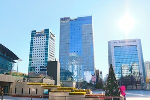 A modern cityscape with high-rise buildings, including a prominent glass skyscraper.