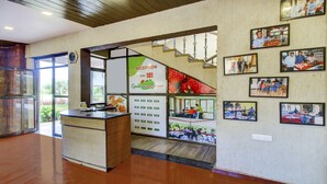 A reception area with a reception desk, a staircase, and framed pictures on the wall. - Treebo Garden Cottage & Lawn Mahabaleshwar (Mahabaleshwar)