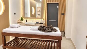 A modern bathroom with a wooden bench, a large mirror, and a dark door.