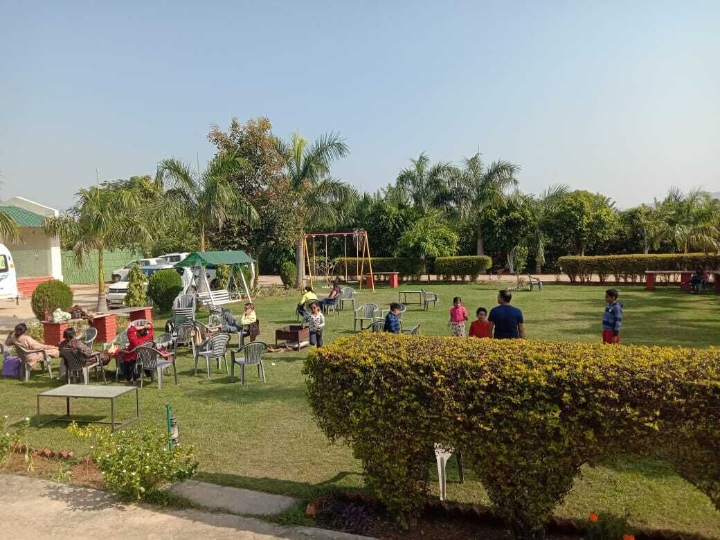 An outdoor area with seating arrangements, a playground, and well-maintained greenery.