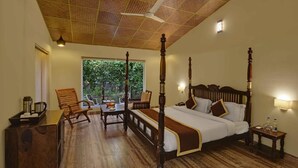 Uma cama de dossel com cabeceira de madeira, um banco de madeira e uma mesa com uma bandeja de objetos.