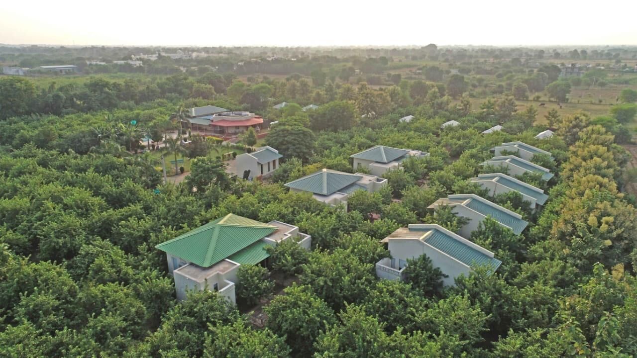 A residential area with multiple houses surrounded by dense greenery.