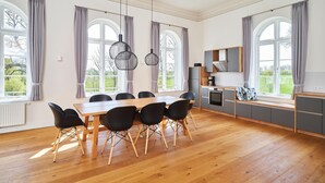 Una cocina amplia con comedor, ventanas grandes y electrodomésticos modernos.
