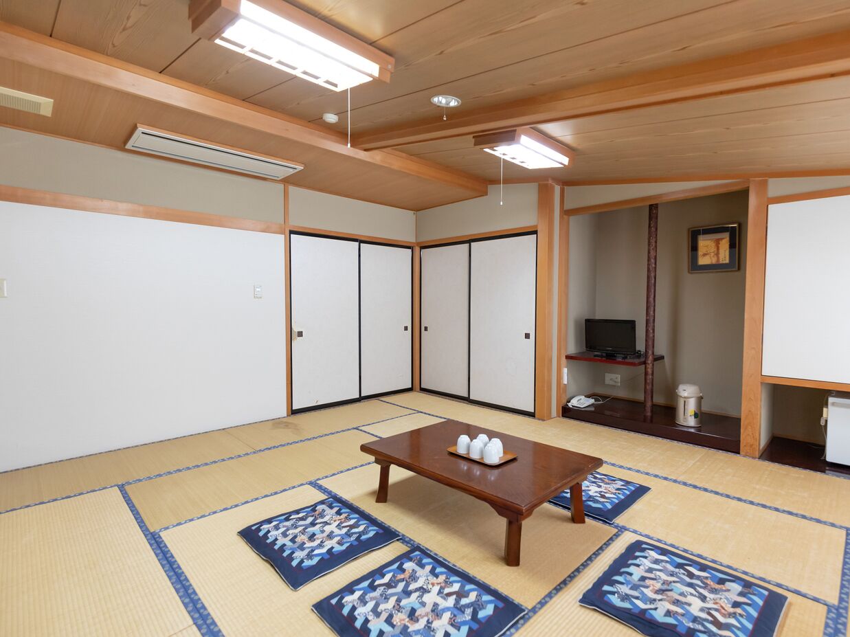 A traditional Japanese room with tatami flooring, a low wooden table, and sliding doors.